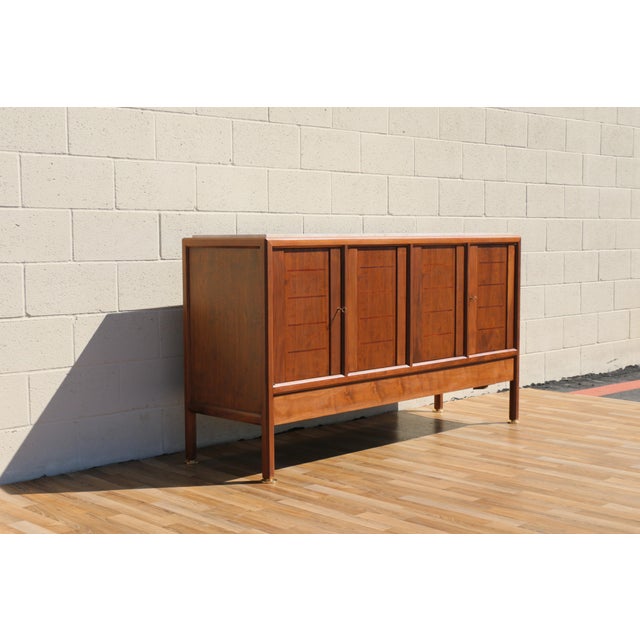Exceptional mid-century modern walnut sideboard credenza by Dunbar, dating from the 1970s. This elegant piece showcases...