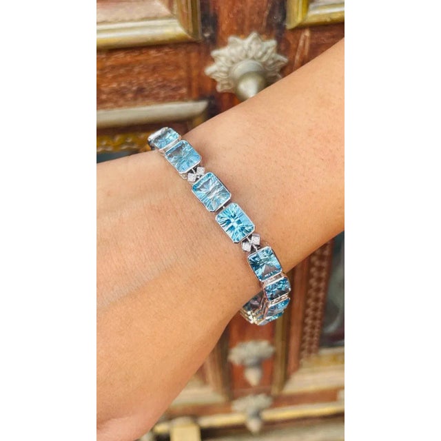 This is part of Chairish’s Fine Jewelry assortment. This Fine Cut 40 ct Blue Topaz and Diamond Tennis Bracelet in 18K gold...