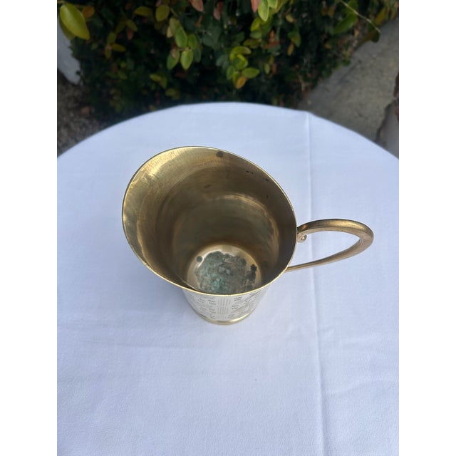 Vintage solid brass pitcher featuring an allover etched geometric pattern of diagonal lines and dotted motifs. The flared...