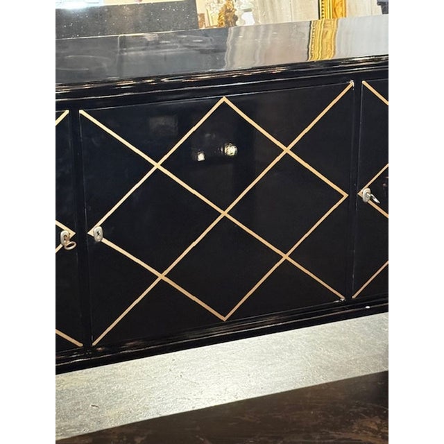 The Italian MCM Design Black and Gold Sideboard after Suzanne Guiguichon, is a stylish and elegant piece of furniture that...