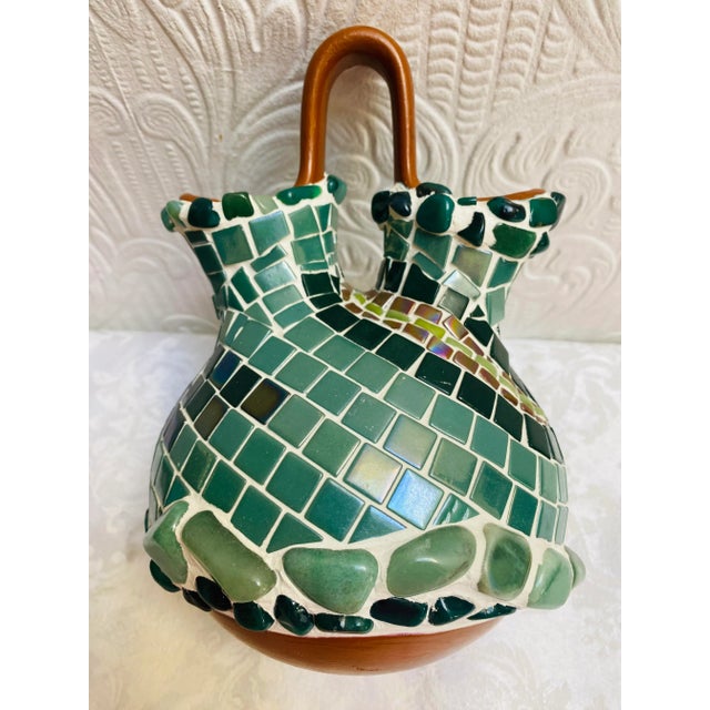 A stunning piece of hand made glass mosaic art on a red pottery southwestern style vase depicting an lizard and river....