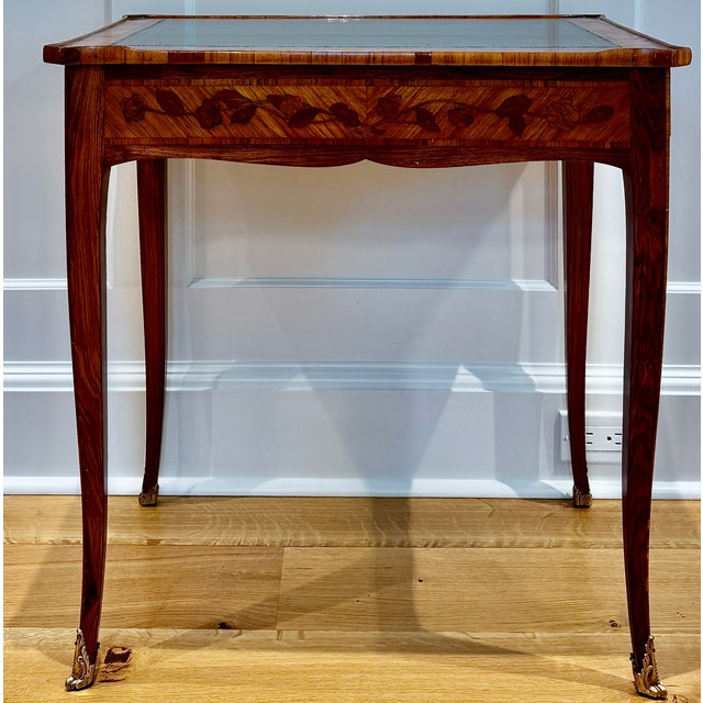 A beautifully restored French Louis XV style writing table with tulipwood and kingwood marquetry, floral inlay, leather...