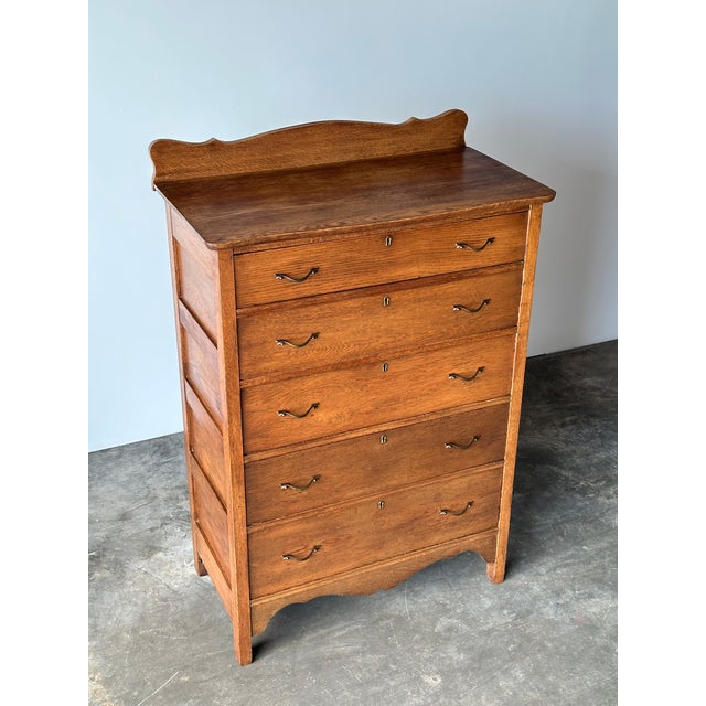 This antique dresser features scalloped detailing at both the shaped backsplash and apron, with five graduated dovetailed...