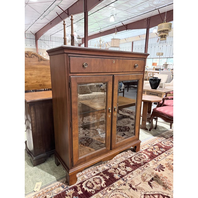 A handsome example of American furniture craftsmanship, this Hekman curio cabinet combines the richness of mahogany with...