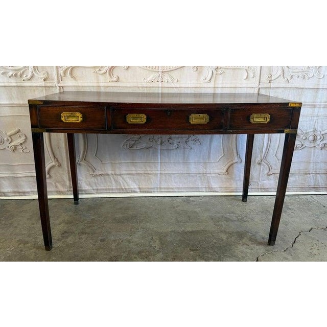 A superb and authentic antique British Colonial Campaign console desk, embodying the refined utilitarian elegance of 19th-...
