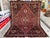 This richly colored Qashqai rug centers on a bold triple-medallion design joined by a traditional pole motif, set against...
