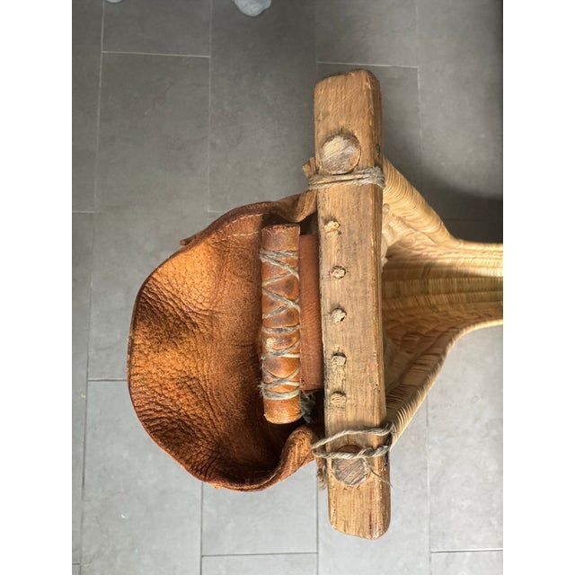 An authentic jai alai cesta, hand-woven from Spanish reed over a bent chestnut rib frame, with a stitched leather glove...