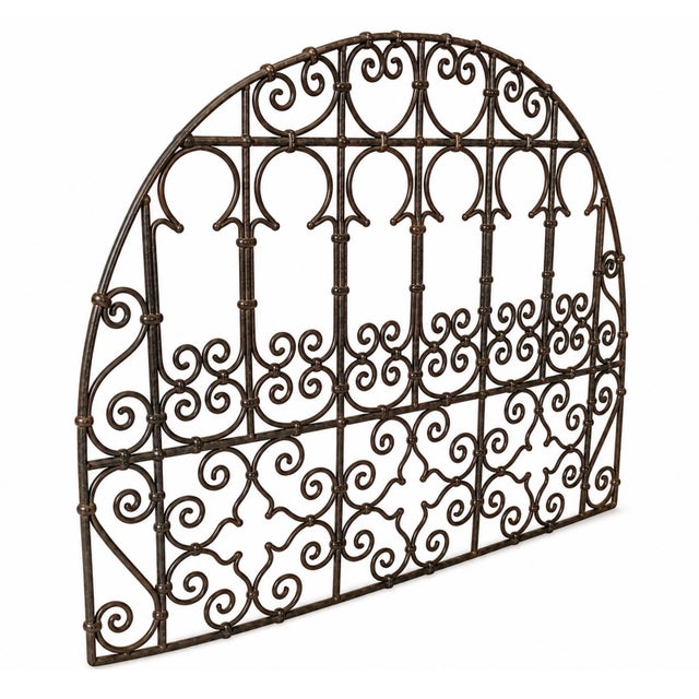 Vintage wrought iron transom panel from India. Featuring elegant hand-forged scrollwork and a graceful arched silhouette,...