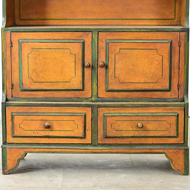 An English graduated or waterfall bookcase from the early 20th Century. This piece is built from pine, which has a layered...
