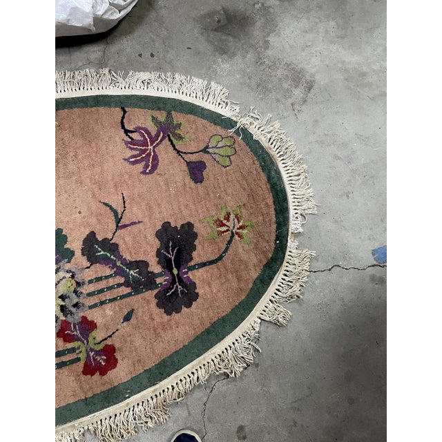 A beautiful handmade antique Chinese Art Deco rug from the 1920s, featuring a refined oval shape and an elegant floral...
