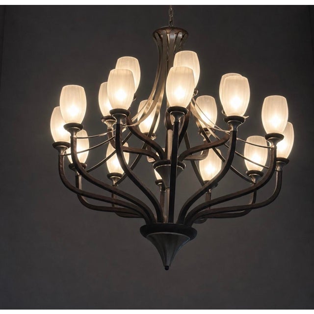 Statement 20-light chandelier featuring sculptural dark wood arms with a brushed nickel frame and hardware, topped with 20...