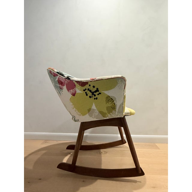 Mid-Century upholstered rocking chair in graphic off-white background large scale floral print. Body shape reminiscent of...