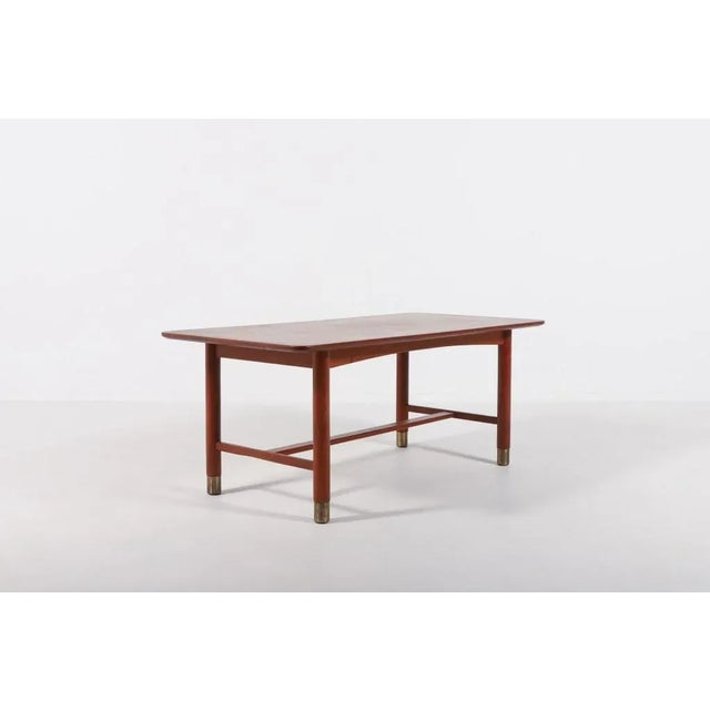 Swedish Modern coffee table in teak from 1960s with brass feet covers, designed by Carl-Axel Acking. Condition Good, age...