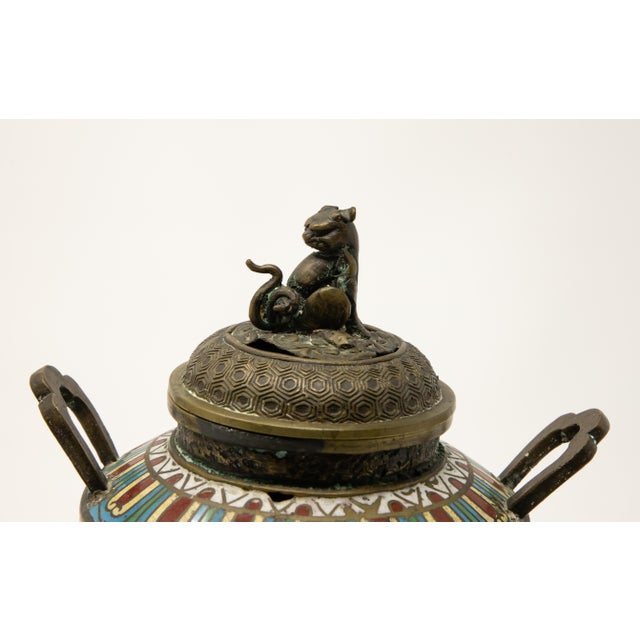 Offering this intriguing Chinese cloisonné bronze censer. Standing on three spiral legs that rise and are joined to the...