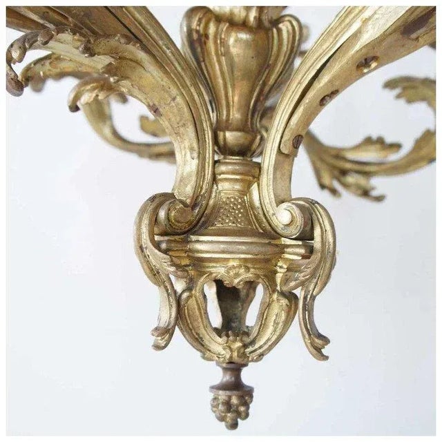 DETAILS This French, antique chandelier is crafted of heavy cast bronze with a gilt, ormolu finish. The frame is...