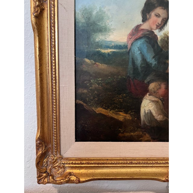 An atmospheric 19th-century European School oil on canvas, depicting a serene pastoral scene with a young woman and child...