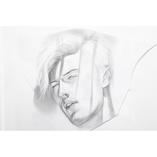A graphite drawing on paper depicting a male portrait by Daniel Samaniego. Circa 2010s. A dramatic black and white...