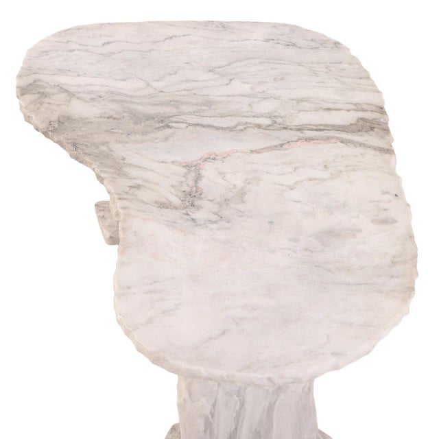 A striking French sculptural coffee table crafted entirely of marble, featuring a free-form organic top supported by two...