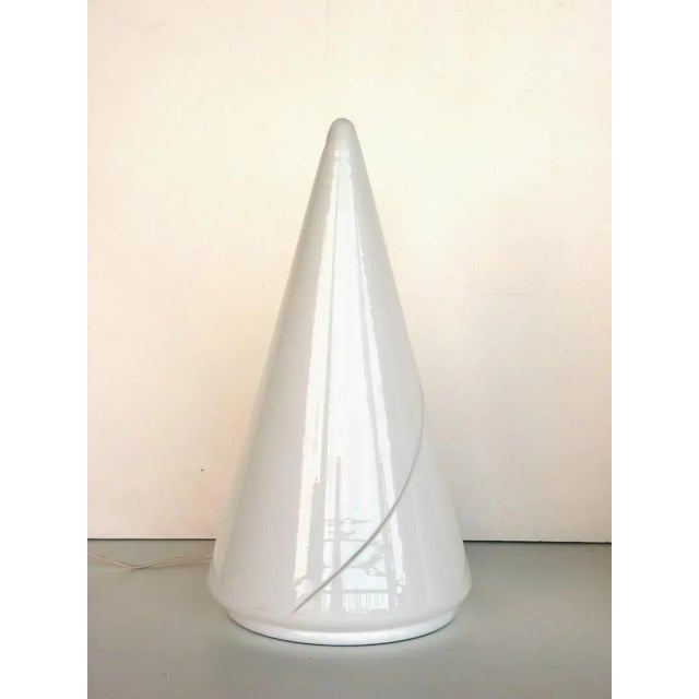 This pair of table lamps in white glass with a painted metal foot features the maker's engraved signature at the glass'...