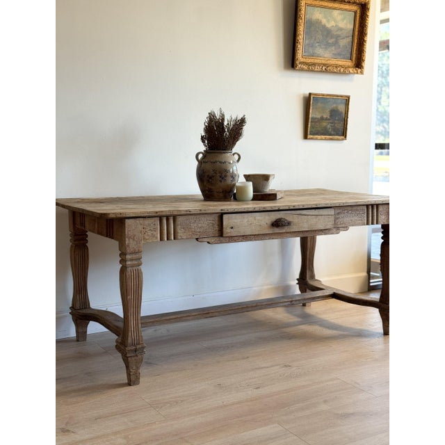 A substantial 19th century French dining table with a beautifully time-softened surface, the wood worn smooth over years...