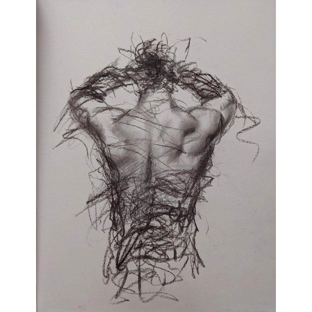 This charcoal drawing captures the dynamic form of a male figure from behind, emphasizing the musculature and contours of...