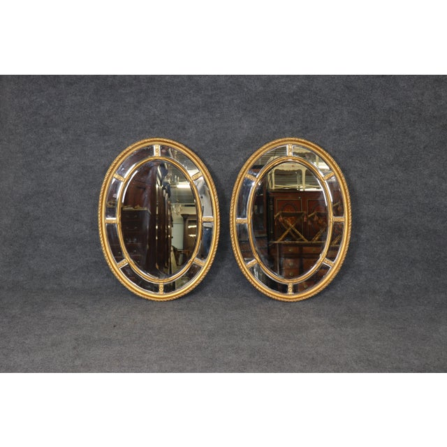 Enhance your interior with this elegant pair of Adams style neoclassical giltwood mirrors, beautifully crafted to reflect...