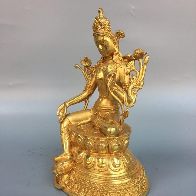 This is a finely crafted gilt bronze sculpture of Green Tara, a revered female Bodhisattva in Tibetan Buddhism known for...