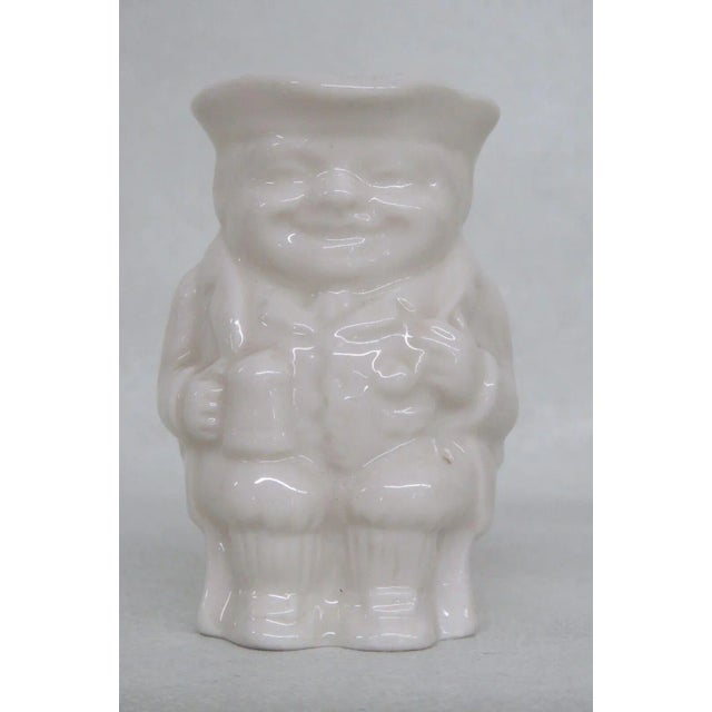 Amazing miniature creamer made in England. This piece showcases a man wearing a colonial uniform holding a mug in hand...