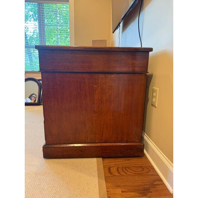 Antique three piece pedestal desk featuring a red embossed leather top with three drawers. Double pedestal bases are on...