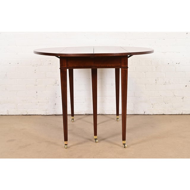 A gorgeous Federal or Regency style drop leaf dining table, breakfast table, or game table By Baker Furniture USA, Circa...