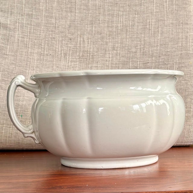 An authentic antique chamber pot by J&G Meakin, crafted in England from durable ironstone china. This piece showcases the...