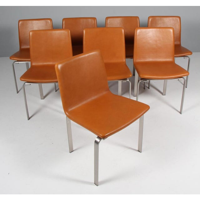 Jørgen Høj set of eight dining chairs in stainless steel. Seat and back upholstered with tan leather. Made by PP møbler....
