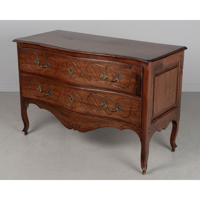 An 18th century Italian Louis XV period walnut commode with elegant serpentine front. Made of solid walnut with fine hand-...