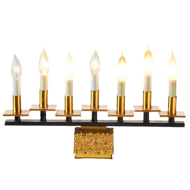 Heavy tabletop electric candelabra or menorah with 7 lights on a rectangular base with a rough brutalist finish. A black...