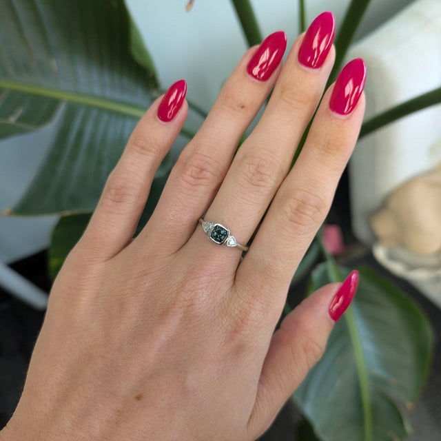 A natural blue spinel glows in a rich, saturated blue at the center of this solid 14K white gold ring, flanked by two...