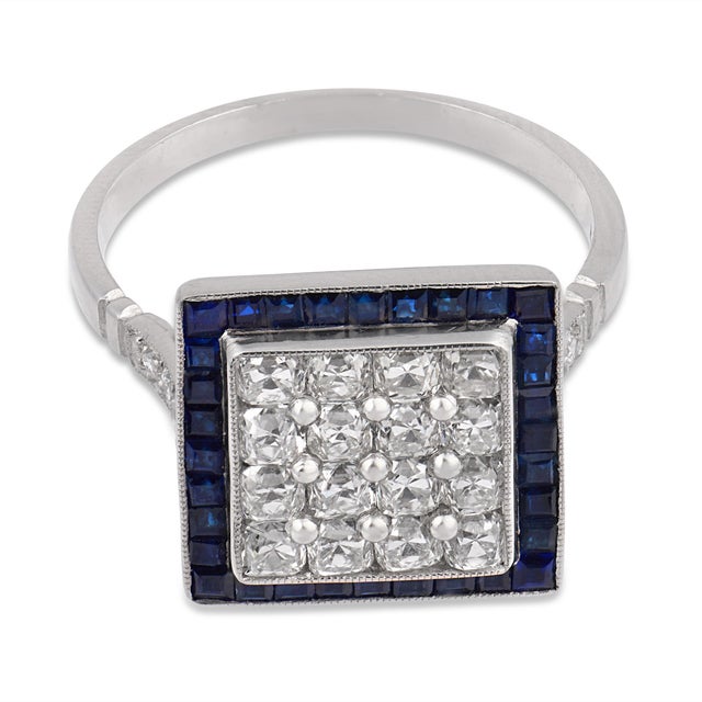 A bold architectural statement inspired by the glamour of the 1930s, this Art Deco–inspired dinner ring showcases sixteen...