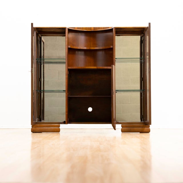 A beautifully crafted English walnut display cabinet dating from the 1950s, blending the elegance of late Art Deco design...