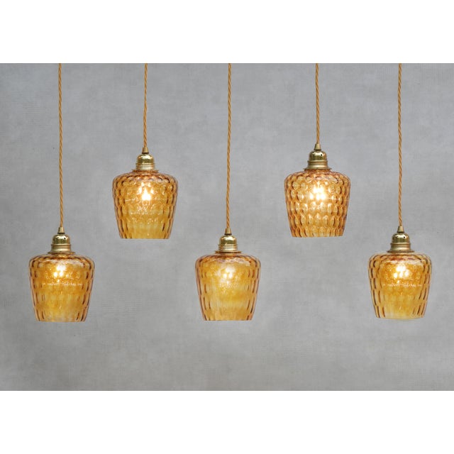 Set of five amber-coloured bubble glass pendant lights from mid-century France. Stylish and versatile these pendant lights...