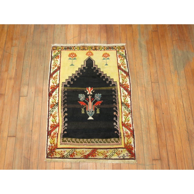 A one-of-a-kind decorative late 19th century Turkish rug with a prayer niche motif featuring on an unusual black color...