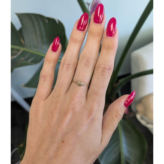 A sweet heart-shaped band in solid 10K yellow gold, a simple and charming everyday piece. A dainty estate ring in...