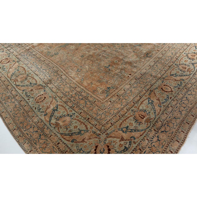 An early 20th-century Persian Kirman antique rug, the abrashed camel field having a garden design of exotic animals and...