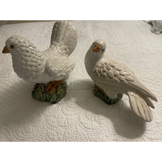 PAIR OF CARVED WHITE BIRDS -small and large size with green ,yellow accents in porcelain large is 7 x8 x5 small is5 x 8 x4"