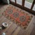 This charming petite rug features a beautifully sun-faded salmon peach background adorned with three striking blue and...