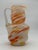 Vintage Italian blown glass pitcher features swirled colors of orange, red, yellow, and white, and has a clear twisted...