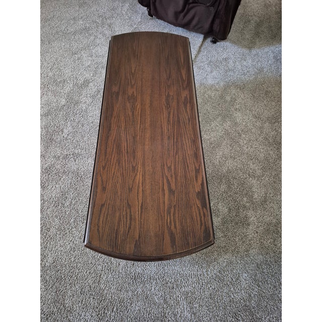 This is a vintage Ethan Allen Style Georgian Court drop-leaf cocktail/coffee table crafted from solid cherry wood. Design...