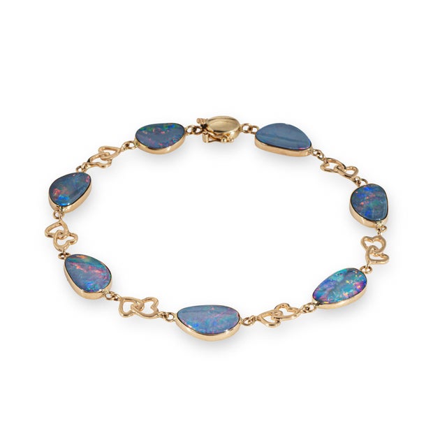 Stylish vintage opal bracelet crafted in 14 karat yellow gold (circa 1980s to 1990s). Opals range in size from 11mm x 8mm...