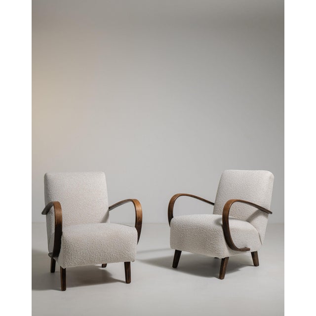 This pair of armchairs makes its impression through cream upholstery, dark wood bentwood arms. It was made in France...