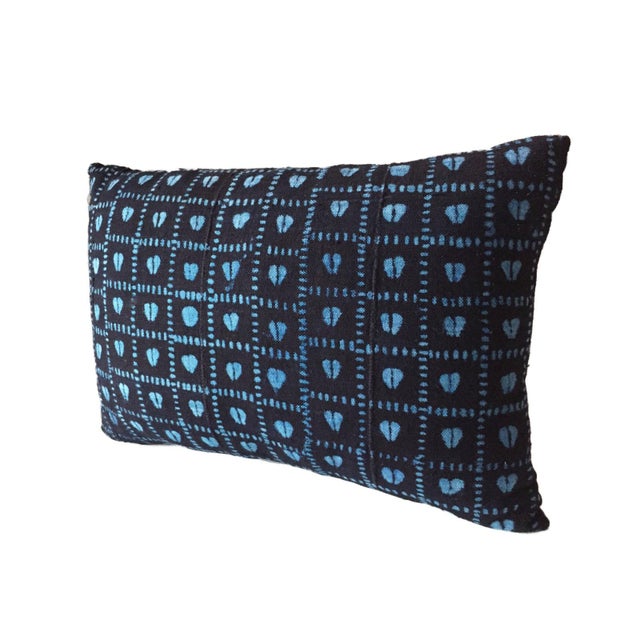 Authentic vintage indigo lumbar pillow featuring a sky blue heart design, handcrafted from West African textiles. Each...