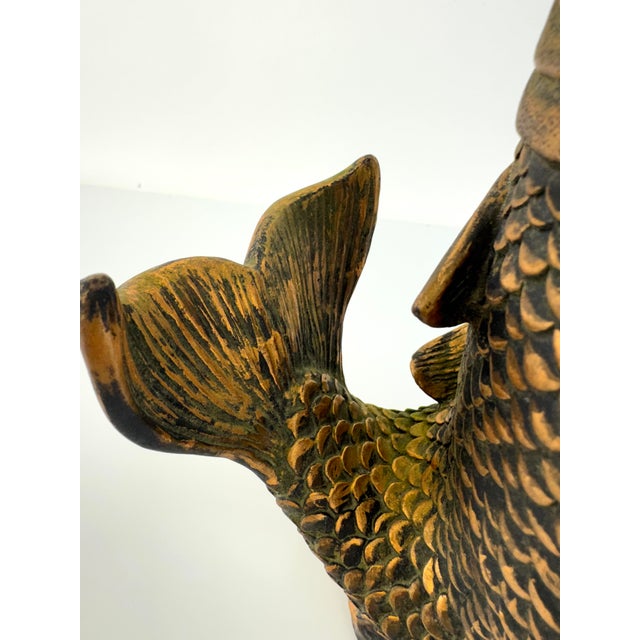 A striking vintage koi fish sculpture rendered in a substantial, heavy cast material with a richly textured aged bronze-...