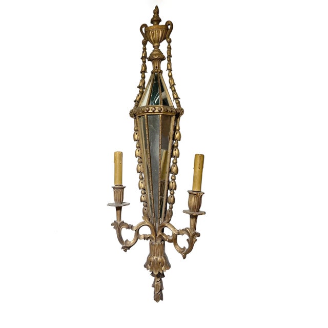 A striking pair of Italian carved wood sconces with inlaid mirrors, circa 1890s. Each sconce features an elegant elongated...